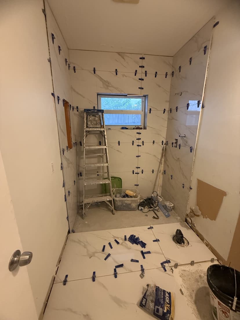 Large-format porcelain going up with leveling clips.