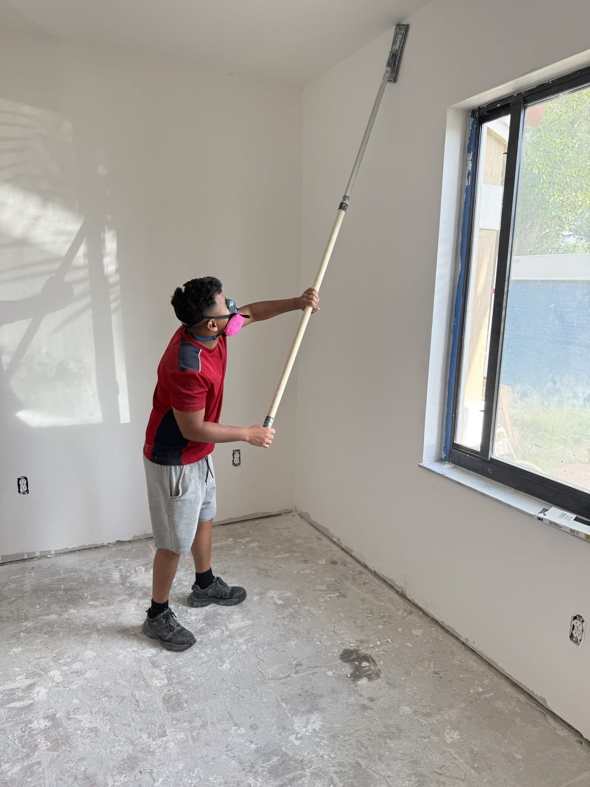 Rolling the first coat on an interior painting job in Miami